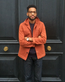A man wearing an orange Albam overshirt with dark washed jeans