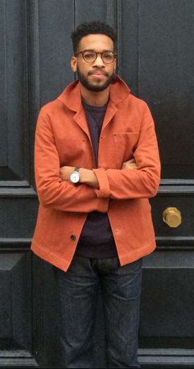 A man wearing an orange Albam overshirt with dark washed jeans