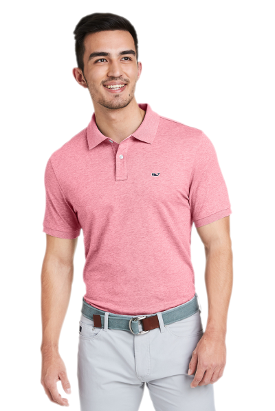 A man wearing a pink Vineyard Vines collared shirt with grey slacks