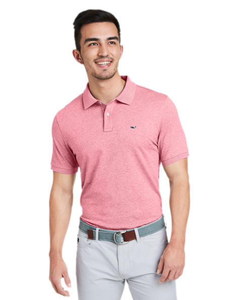 A man wearing a pink Vineyard Vines collared shirt with grey slacks