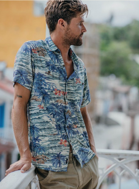 A man wearing a blue Hawaiian button up from Faherty