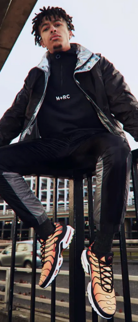 A man wearing a m+rc noir baclk fleece, jacket and track pants
