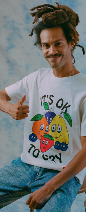 A man wearing a It's okay to Cry' chnge white t-shirt with fruits on it