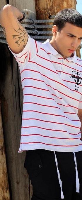 A man wearing a striped red and white Akademiks polo shirt