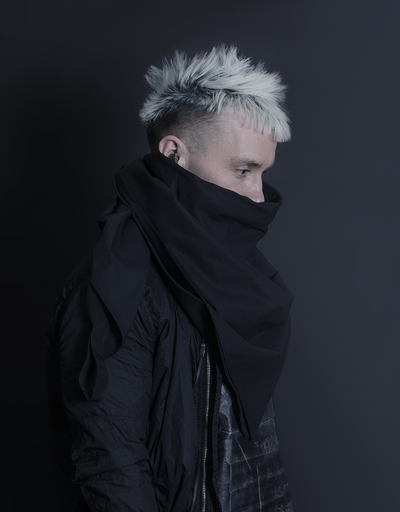 A man wearing a oversize AOKU black scarf and jacket