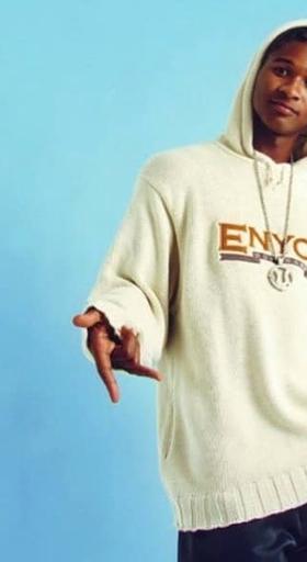A man wearing an ENCYE cream branded hoodie with a large chain