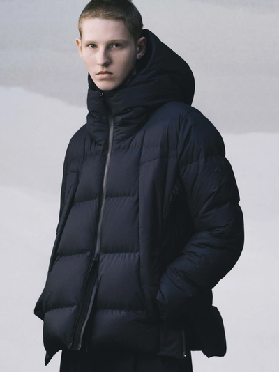 A man wearing a black DESCENTE ALLTERRAIN puffy jacket