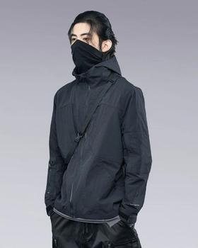 A man wearing a clotechnow black outfit featuring a black mask and technical jacket