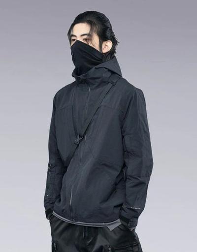 A man wearing a clotechnow black outfit featuring a black mask and technical jacket