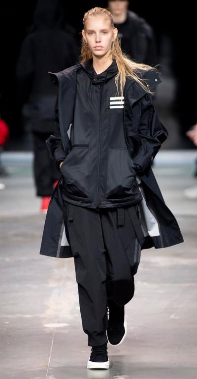 A man wearing a Y-3 black technical outfit walking the runway