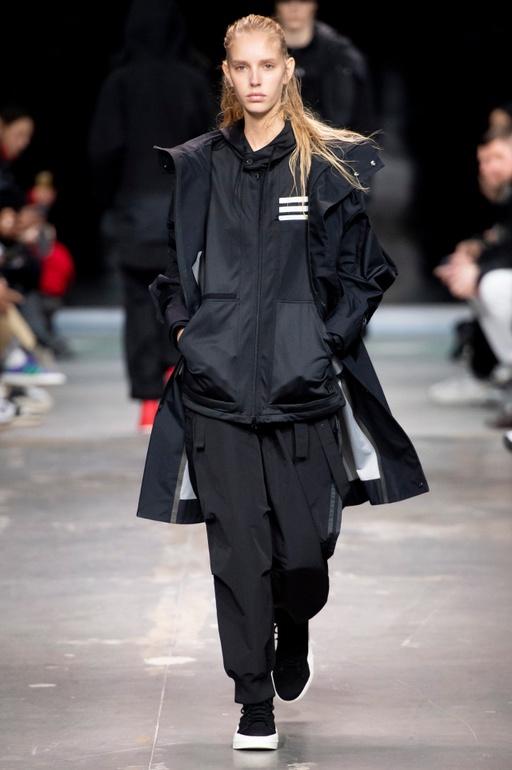 A man wearing a Y-3 black technical outfit walking the runway