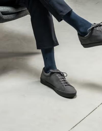 A man wearing JAK minimalist dark grey shoes