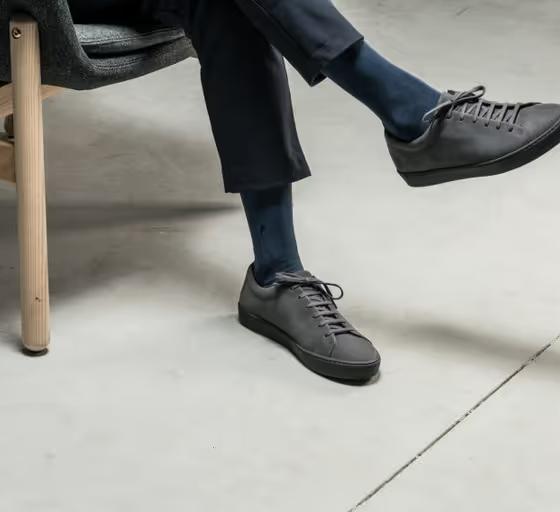 A man wearing JAK minimalist dark grey shoes