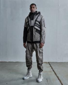 A man wearing a ENFIN LEVÉ grey technical jacket and matching pants
