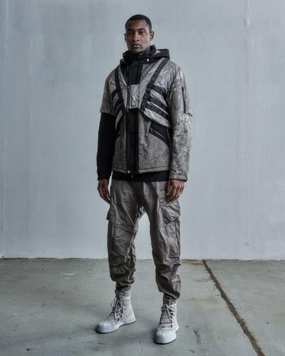 A man wearing a ENFIN LEVÉ grey technical jacket and matching pants