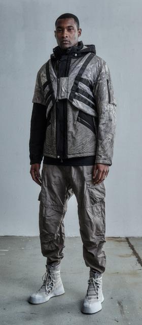 A man wearing a ENFIN LEVÉ grey technical jacket and matching pants