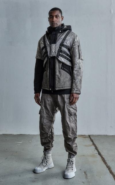 A man wearing a ENFIN LEVÉ grey technical jacket and matching pants