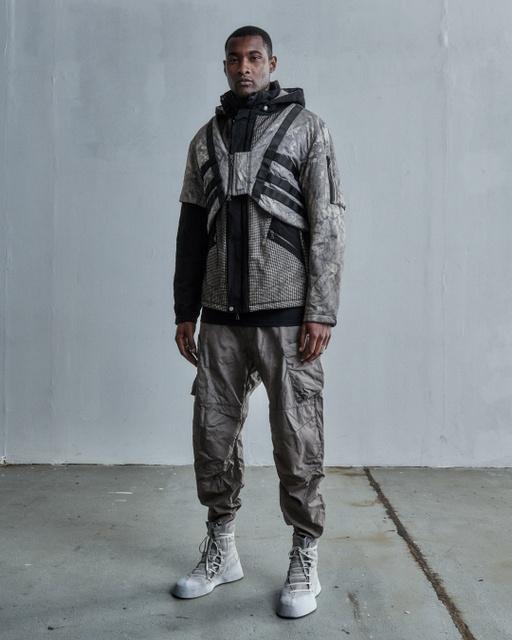 A man wearing a ENFIN LEVÉ grey technical jacket and matching pants