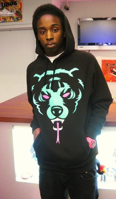 A man wearing a classic light blue and pink Mishka bear hoodie