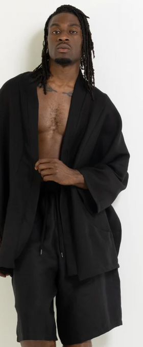 A man wearing a black flowing Mercy House outfit