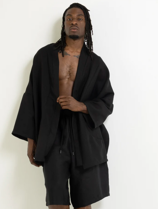 A man wearing a black flowing Mercy House outfit