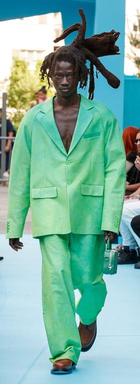 A man walking the runway in a green oversize suit by 3.Paradis