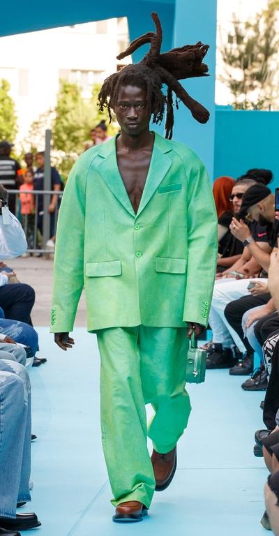 A man walking the runway in a green oversize suit by 3.Paradis