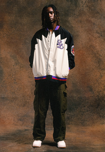 A man wearing a Raptors Inspired The Legends League coaches jacket