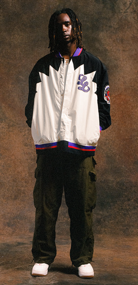 A man wearing a Raptors Inspired The Legends League coaches jacket