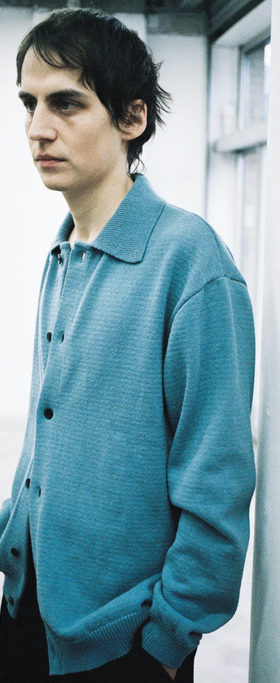 A man wearing a mfpen blue button-up colored sweater