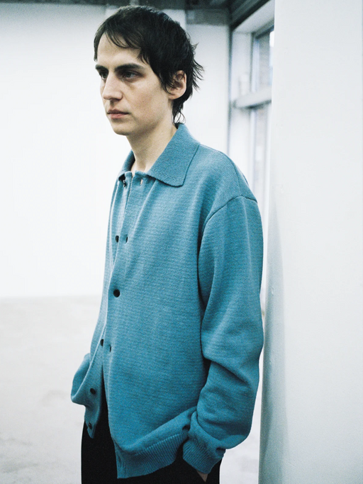 A man wearing a mfpen blue button-up colored sweater