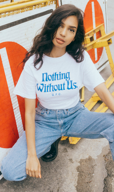 A woman wearing a 'nothing without us' Get Fresh Company t-shirt and blue jeans