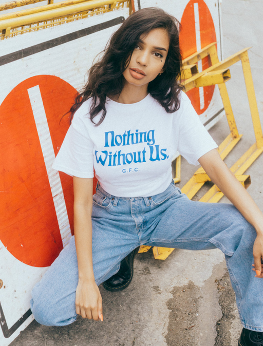 A woman wearing a 'nothing without us' Get Fresh Company t-shirt and blue jeans