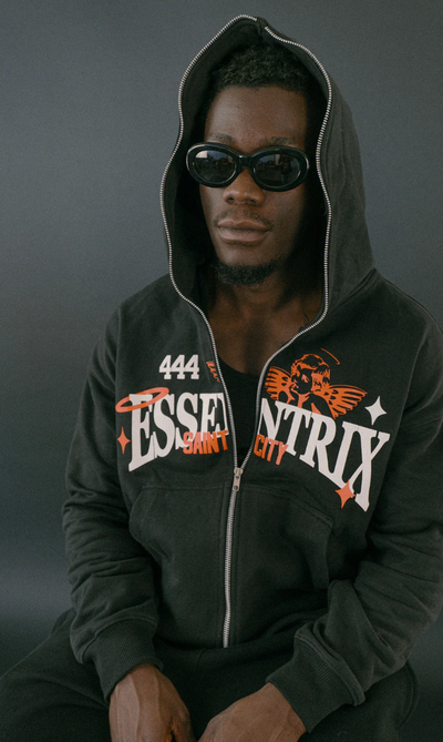 A man wearing an Essentrix branded zip up hoodie with sunglasses