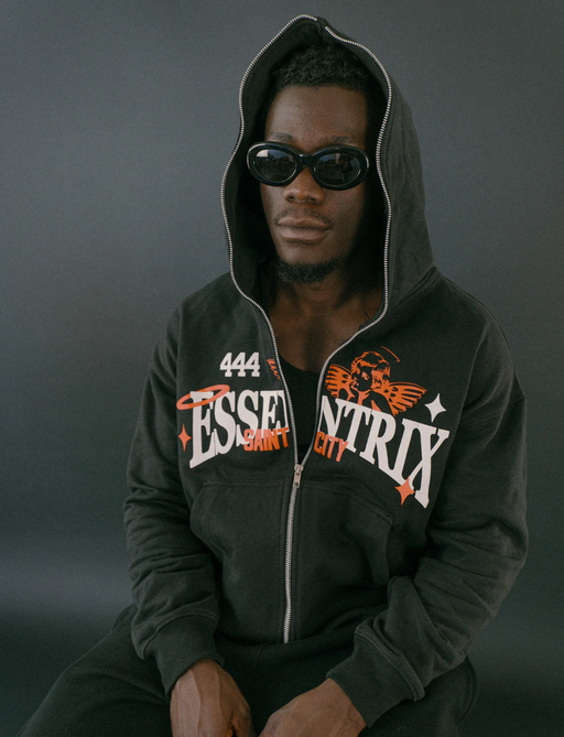 A man wearing an Essentrix branded zip up hoodie with sunglasses