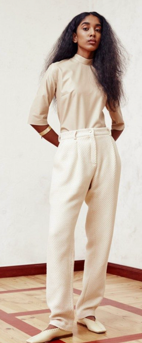 A woman wearing comfortable beige pants and long-sleeve by Hien Le