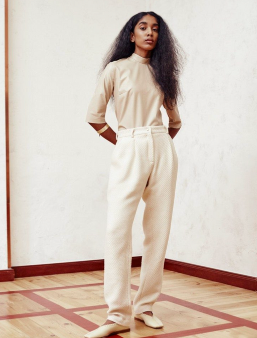 A woman wearing comfortable beige pants and long-sleeve by Hien Le