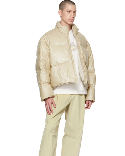 A man wearing an AMOMENTO light biege jacket and pants with a white t-shirt