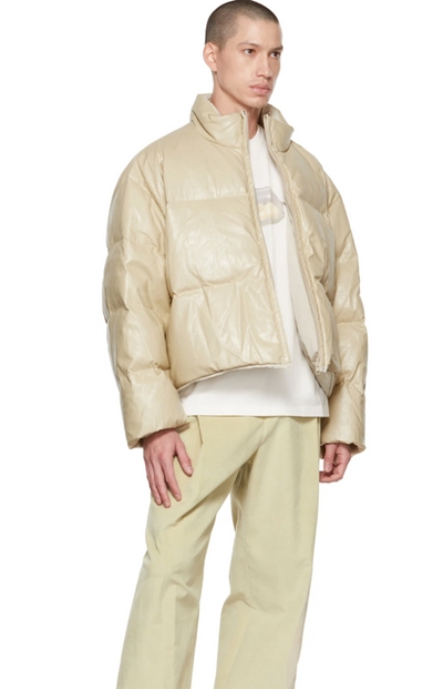 A man wearing an AMOMENTO light biege jacket and pants with a white t-shirt