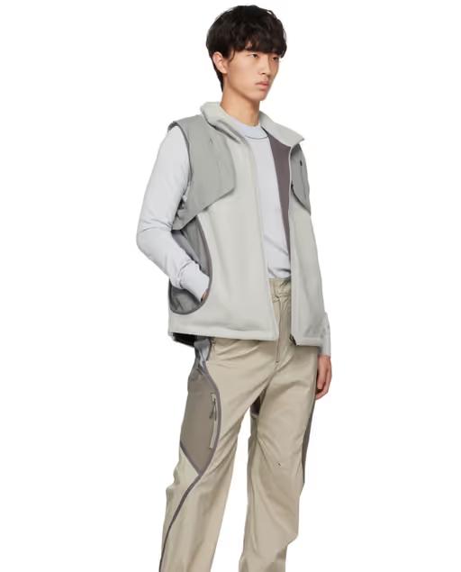 A man wearing a grey Hyein Seo vest and beige pants