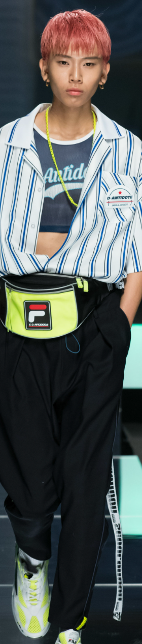 A man wearing a striped D-antidote button up with a fanny pack
