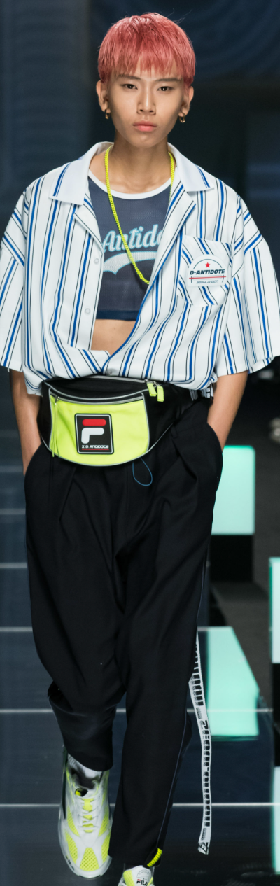A man wearing a striped D-antidote button up with a fanny pack