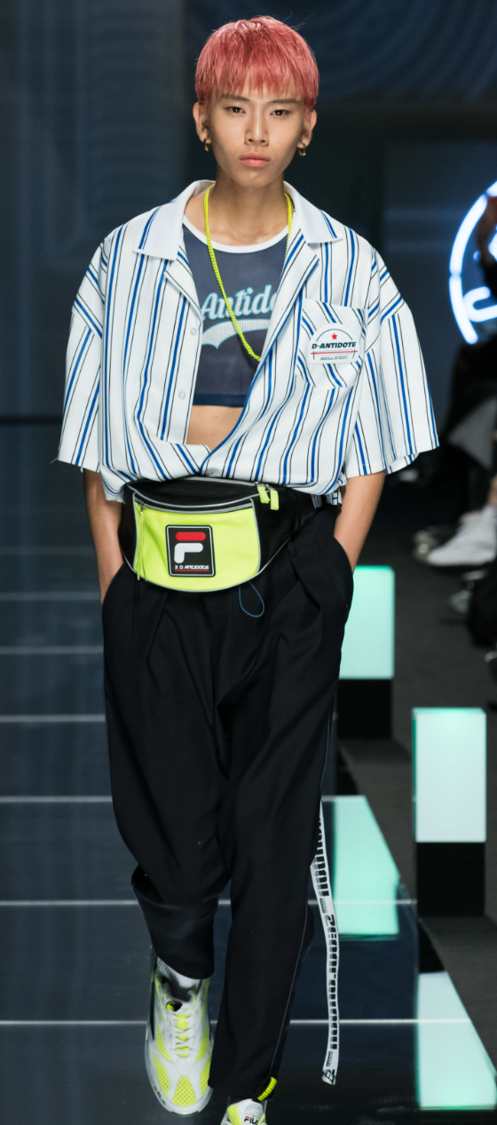 A man wearing a striped D-antidote button up with a fanny pack