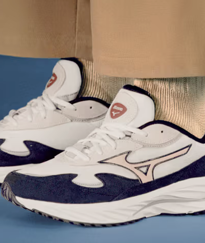 A man wearing a white and navy blue Mizuno runners