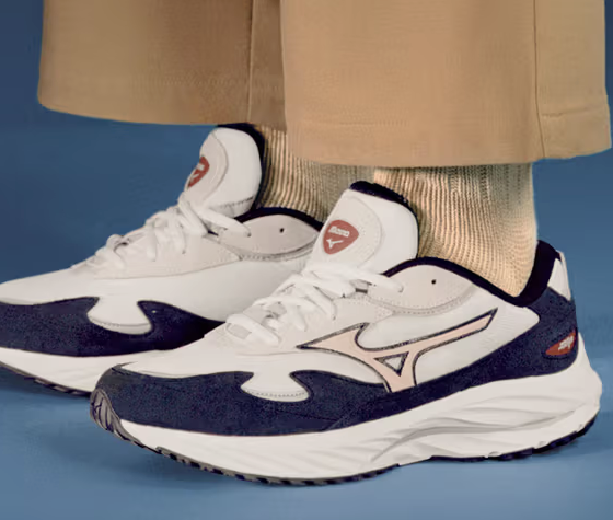 A man wearing a white and navy blue Mizuno runners