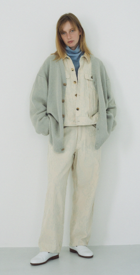A woman wearing a light blue cardigan by URU along with cream button up with matching pants