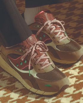 A man wearing a pair of brown and colorful Saucony runners