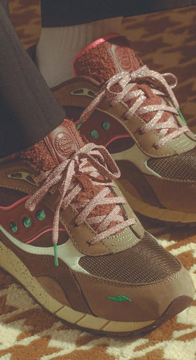 A man wearing a pair of brown and colorful Saucony runners