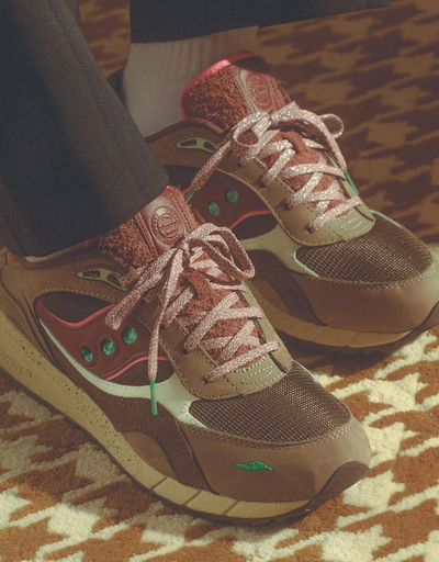 A man wearing a pair of brown and colorful Saucony runners
