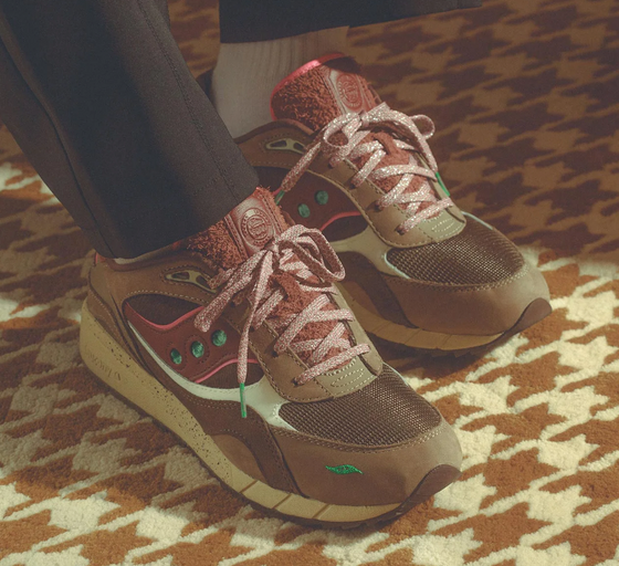 A man wearing a pair of brown and colorful Saucony runners